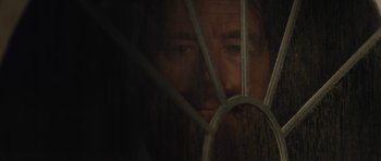 Movie still from “Wakefield” (2016), directed by Robin Swicord – A person looking through a fence; Extreme Close Up shot, Over the shoulder angle