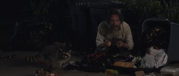 Movie still from “Wakefield” (2016), directed by Robin Swicord – A man sitting on the ground with a racoon; Medium shot, Low angle