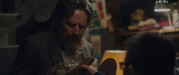 Movie still from “Wakefield” (2016), directed by Robin Swicord – A man with a beard is looking at a shoe; Close Up shot, Over the shoulder angle
