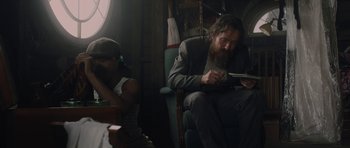 Movie still from “Wakefield” (2016), directed by Robin Swicord – A man sitting in a chair while a woman looks on; Medium shot, Over the shoulder angle