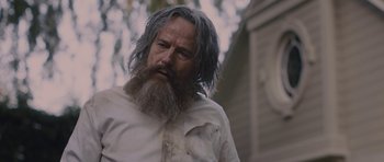 Movie still from “Wakefield” (2016), directed by Robin Swicord – A man with long grey hair and a beard; Close Up shot, Low angle