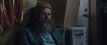 Movie still from “Wakefield” (2016), directed by Robin Swicord – A man with a long beard sitting on a chair; Close Up shot, Low angle