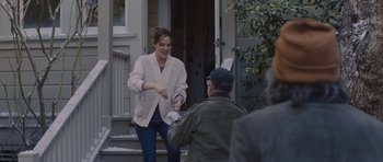 Movie still from “Wakefield” (2016), directed by Robin Swicord – A woman is handing an item to an older man; Medium shot, Over the shoulder angle