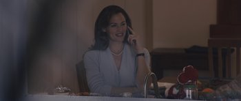 Movie still from “Wakefield” (2016), directed by Robin Swicord – A woman sitting at a table talking on a cell phone; Medium shot, Over the shoulder angle