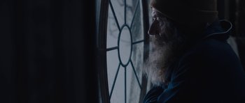 Movie still from “Wakefield” (2016), directed by Robin Swicord – An old man looking out of a window at night; Close Up shot, Over the shoulder angle