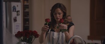 Movie still from “Wakefield” (2016), directed by Robin Swicord – A beautiful woman holding two roses in a kitchen; Close Up shot, Over the shoulder angle