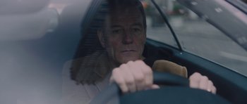 Movie still from “Wakefield” (2016), directed by Robin Swicord – An older man driving a car with a teddy bear in his hand; Close Up shot, Over the shoulder angle