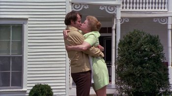 Movie still from “Walking Tall” (1973), directed by Phil Karlson – A man and a woman kissing in front of a white house; Medium shot, Low angle
