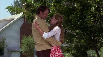 Movie still from “Walking Tall” (1973), directed by Phil Karlson – A man and a woman embracing in front of a tree; Medium shot, Low angle
