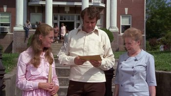 Movie still from “Walking Tall” (1973), directed by Phil Karlson – Two women and a man looking at a piece of paper; Medium shot, Over the shoulder angle