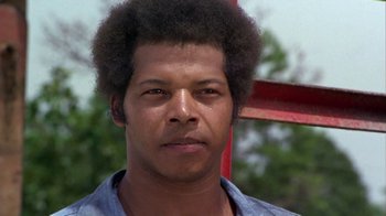 Movie still from “Walking Tall” (1973), directed by Phil Karlson – A person wearing a blue shirt; Close Up shot, Low angle