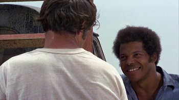 Movie still from “Walking Tall” (1973), directed by Phil Karlson – A man talking to another man in front of a truck; Close Up shot, Over the shoulder angle