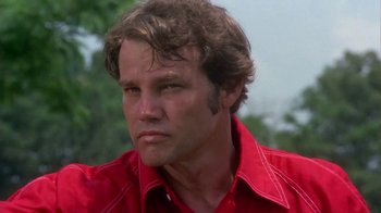 Movie still from “Walking Tall” (1973), directed by Phil Karlson – A person wearing a red shirt; Close Up shot, Low angle
