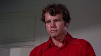 Movie still from “Walking Tall” (1973), directed by Phil Karlson – A person wearing a red shirt; Close Up shot, Low angle