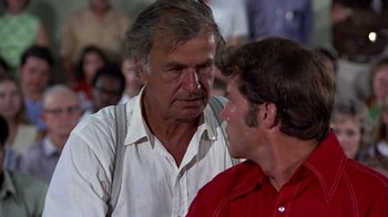 Movie still from “Walking Tall” (1973), directed by Phil Karlson – A man and a man talking to each other; Close Up shot, Over the shoulder angle