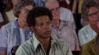 Movie still from “Walking Tall” (1973), directed by Phil Karlson – An african american man in a crowd of people; Close Up shot, High angle