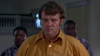 Movie still from “Walking Tall” (1973), directed by Phil Karlson – A man in a yellow shirt and three other men; Close Up shot, Low angle