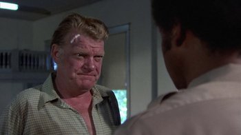 Movie still from “Walking Tall” (1973), directed by Phil Karlson – A man is looking at another man in a room; Close Up shot, Over the shoulder angle