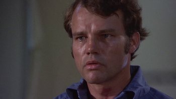 Movie still from “Walking Tall” (1973), directed by Phil Karlson – A man's face in a blue shirt; Close Up shot, Low angle