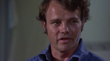 Movie still from “Walking Tall” (1973), directed by Phil Karlson – A person wearing a blue shirt; Close Up shot, Low angle