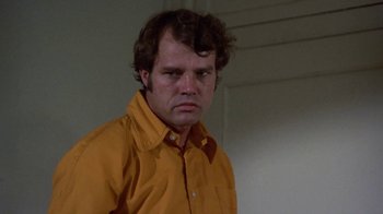 Movie still from “Walking Tall” (1973), directed by Phil Karlson – A person wearing an orange shirt; Close Up shot, Low angle