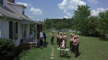 Movie still from “Walking Tall” (1973), directed by Phil Karlson – A group of people standing in the grass; Wide shot, High angle