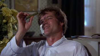 Movie still from “Walking Tall” (1973), directed by Phil Karlson – A man is holding a piece of food up to his face; Close Up shot, Low angle
