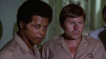 Movie still from “Walking Tall” (1973), directed by Phil Karlson – A couple of men standing next to each other; Close Up shot, Low angle