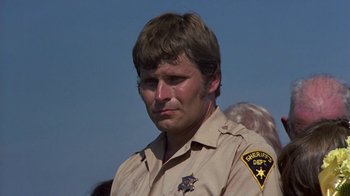Movie still from “Walking Tall” (1973), directed by Phil Karlson – A man in a sheriff's uniform looking at the camera; Close Up shot, Low angle