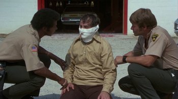 Movie still from “Walking Tall” (1973), directed by Phil Karlson – A man with bandages around his face is being bandaged; Medium shot, High angle