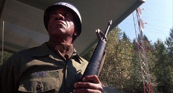 Movie still from “WarGames” (1983), directed by John Badham – A man holding a rifle in his hands; Close Up shot, Low angle