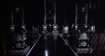 Movie still from “WarGames” (1983), directed by John Badham – A group of people sitting on chairs in a dark room; Extreme Wide shot, High angle