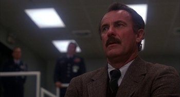 Movie still from “WarGames” (1983), directed by John Badham – A man in a suit and tie looking up; Close Up shot, Low angle