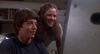 Movie still from “WarGames” (1983), directed by John Badham – A young man and a young woman smiling for the camera; Close Up shot, Low angle