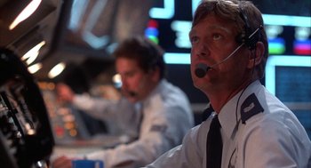 Movie still from “WarGames” (1983), directed by John Badham – A man with a headset is sitting in front of another man; Close Up shot, Low angle