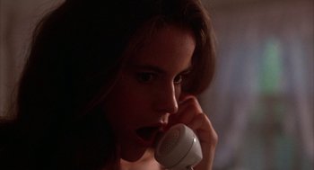 Movie still from “WarGames” (1983), directed by John Badham – A young woman holding a phone up to her mouth; Close Up shot, Low angle