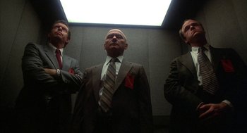 Movie still from “WarGames” (1983), directed by John Badham – A group of men in suits standing next to each other in an elevator; Medium shot, Low angle