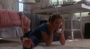 Movie still from “WarGames” (1983), directed by John Badham – A woman talking on a phone while lying on the floor; Medium shot, High angle