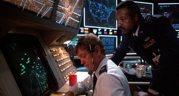 Movie still from “WarGames” (1983), directed by John Badham – Two men working on a computer in front of multiple monitors; Medium shot, Low angle