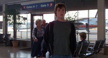 Movie still from “WarGames” (1983), directed by John Badham – A young man walking through an airport terminal; Wide shot, Low angle