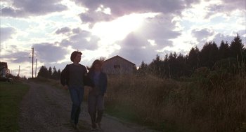 Movie still from “WarGames” (1983), directed by John Badham – Two people are walking down a dirt road near a barn; Wide shot, Low angle