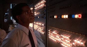 Movie still from “WarGames” (1983), directed by John Badham – A man standing in front of a bunch of lights; Close Up shot, Low angle