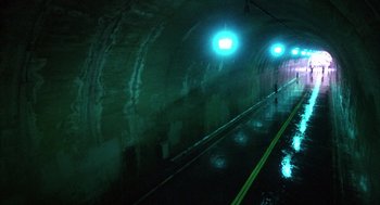 Movie still from “WarGames” (1983), directed by John Badham – A dark tunnel with green lights on the side of it; Extreme Wide shot, High angle