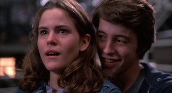 Movie still from “WarGames” (1983), directed by John Badham – A young man and a young woman looking at the camera; Close Up shot, Over the shoulder angle