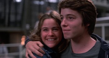 Movie still from “WarGames” (1983), directed by John Badham – A man and a woman smiling for the camera; Close Up shot, Low angle