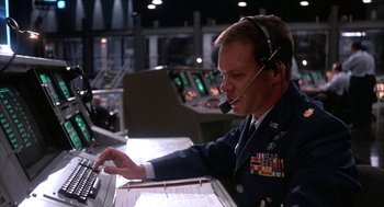 Movie still from “WarGames” (1983), directed by John Badham – A man in a military uniform working on a computer; Medium shot, Low angle
