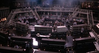 Movie still from “WarGames” (1983), directed by John Badham – A group of people standing in a large room; Extreme Wide shot, High angle