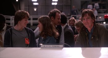 Movie still from “WarGames” (1983), directed by John Badham – A group of people sitting around a table; Medium shot, Over the shoulder angle