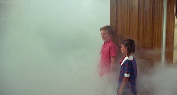 Movie still from “Watermelon Man” (1970), directed by Melvin Van Peebles – Two young children standing in front of a wall of smoke; Medium shot, High angle