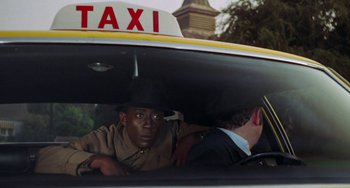 Movie still from “Watermelon Man” (1970), directed by Melvin Van Peebles – A man in a taxi cab looking out of the window; Close Up shot, Over the shoulder angle